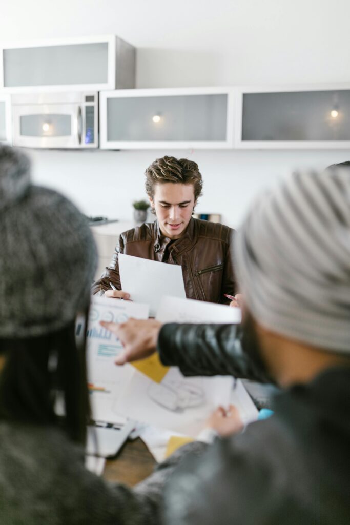 A diverse team having a brainstorming session indoors, focused on planning and teamwork.