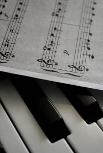A detailed view of piano keys alongside a sheet of musical notation, emphasizing harmony.